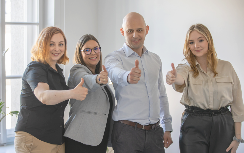 3 kobiety i mężczyzna pokazują kciuki