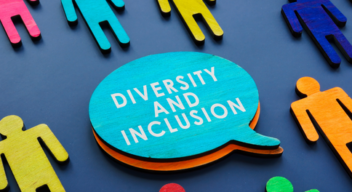 Na niebieskim tle ułożone są kolorowe figurki przedstawiające człowieka. W środku dymek z napisem diversity and inclusion.