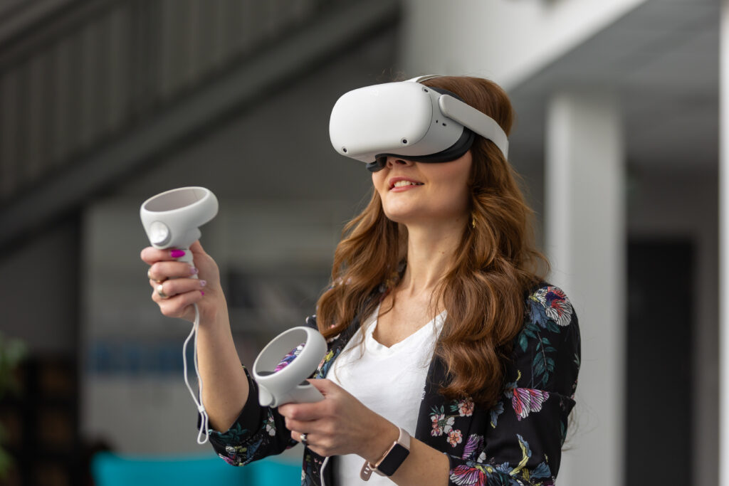 Osoba z goglami VR na głosie trzyma kontrolery w dłoniach