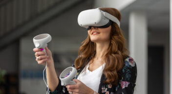 Osoba z goglami VR na głosie trzyma kontrolery w dłoniach
